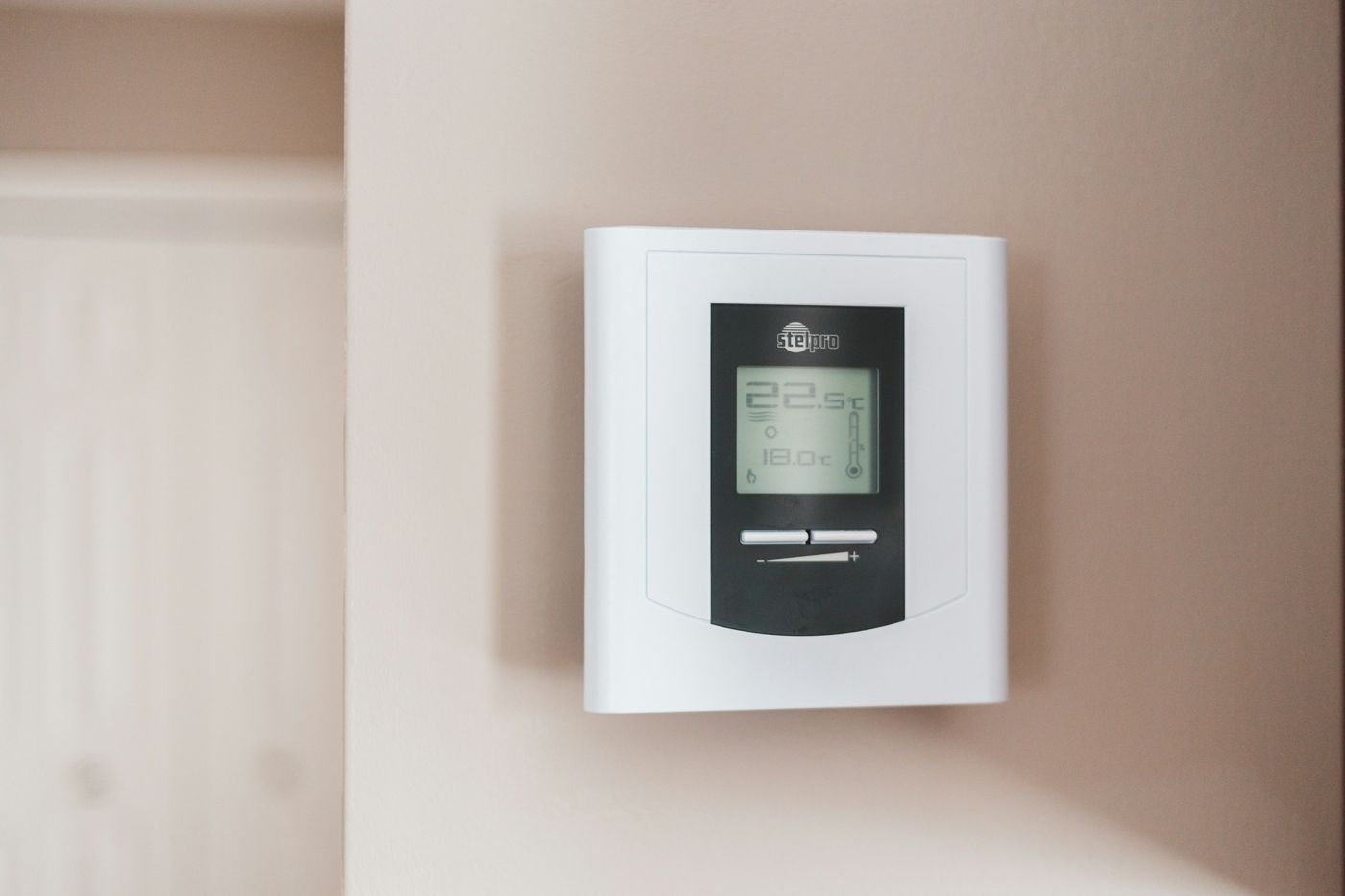 Digital thermostat mounted on an interior wall