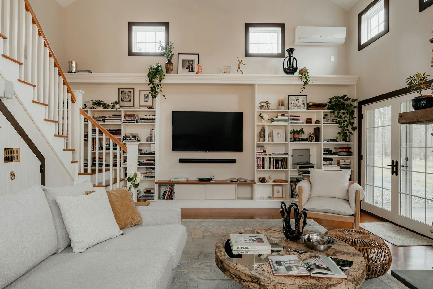 Family room with a wall-mounted TV, built-in shelves and a sectional sofa