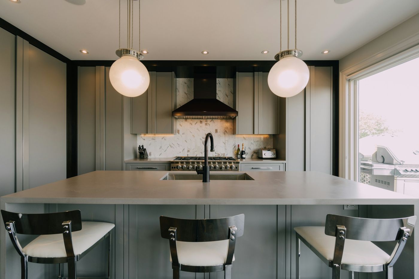 Kitchen with a center island, pendant lights and bar stools