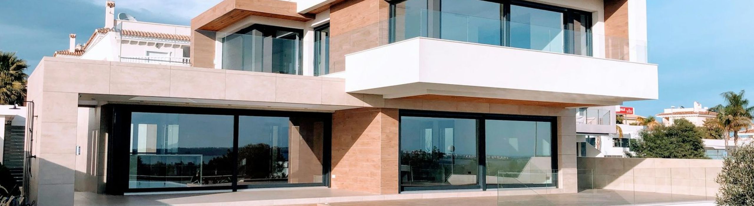 Modern two-story home with large windows and a swimming pool