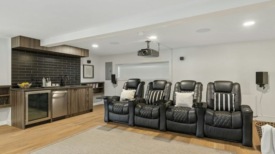 Media room with four leather theater recliners, a ceiling-mounted projector and a wet bar