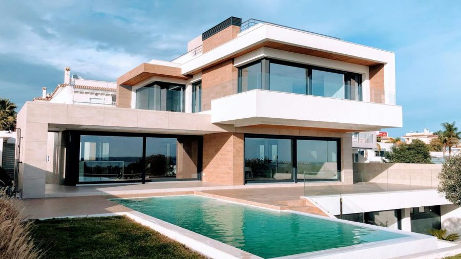 Modern two-story home with large windows and a swimming pool
